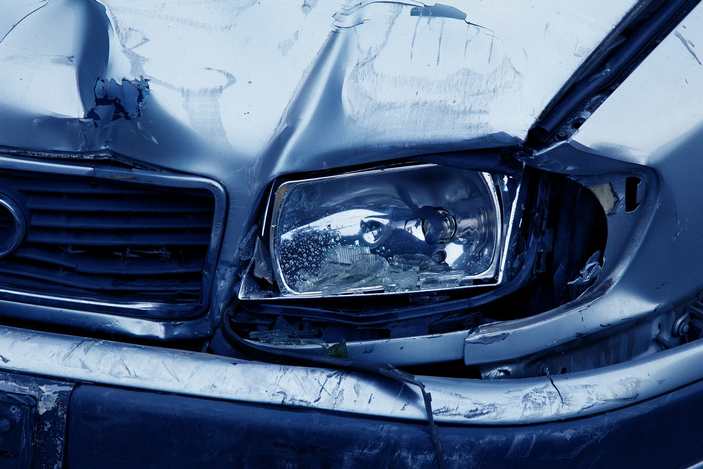 close-up of the front of a car with a smashed headlight and fender.