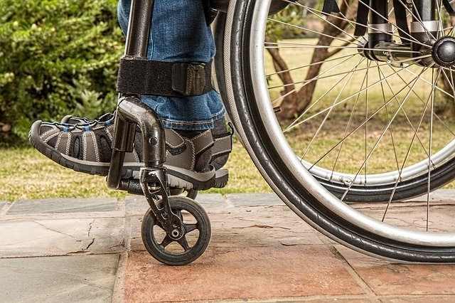 Close up of a person's legs and feet in a wheelchair.