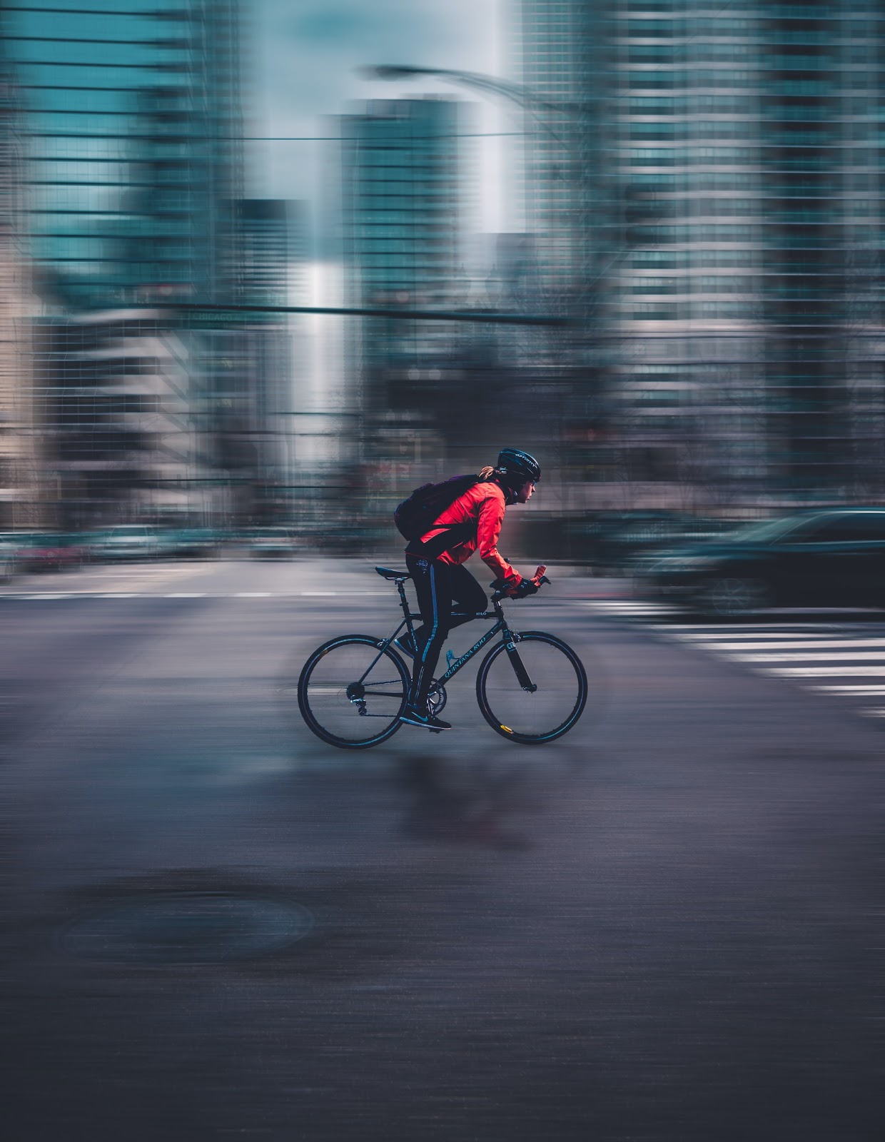 Cyclist wearing a helmet with a blurred city background.